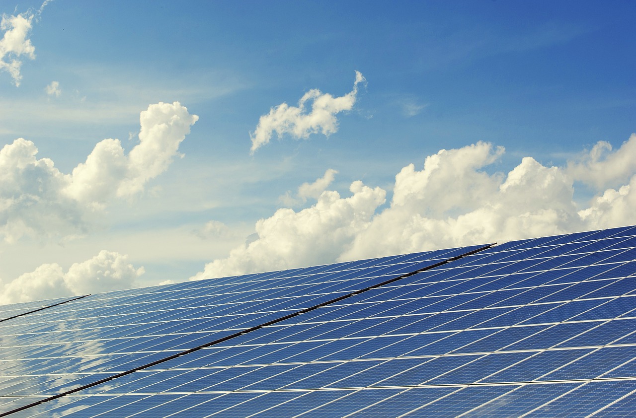 a large solar array with clouds in the sky